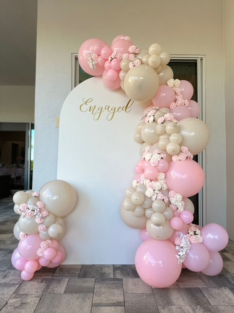 Pink, blush, and cream organic balloon arch with floral accents and gold Engaged sign