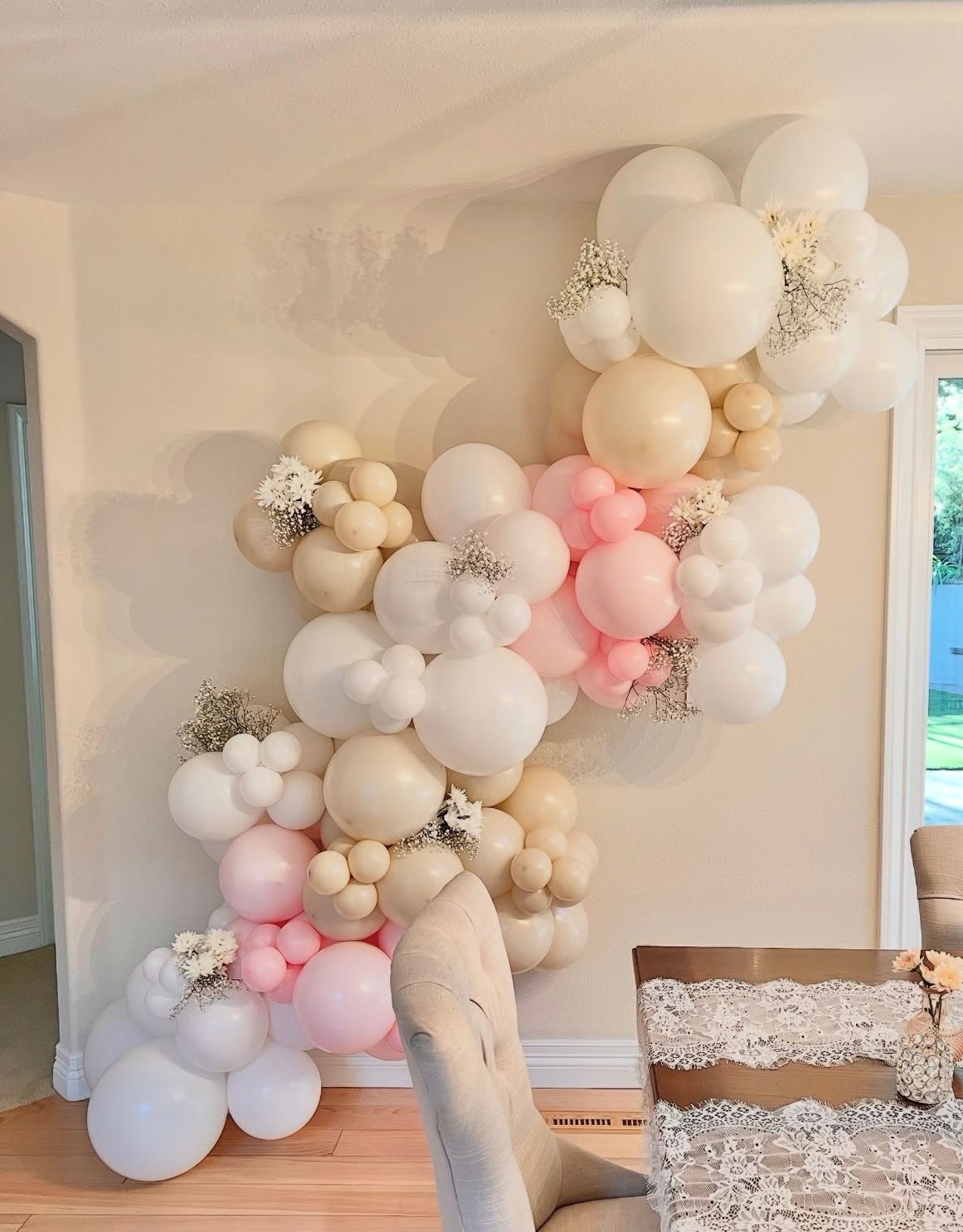 White, cream, and blush organic balloon garland with baby's breath florals