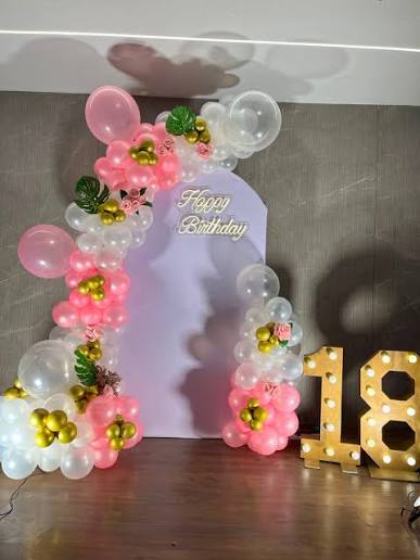 Light-up marquee number 18 with pink, white, and gold balloon arch
